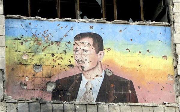 A colourful facade depicting President Assad is riddled with bullet holes.