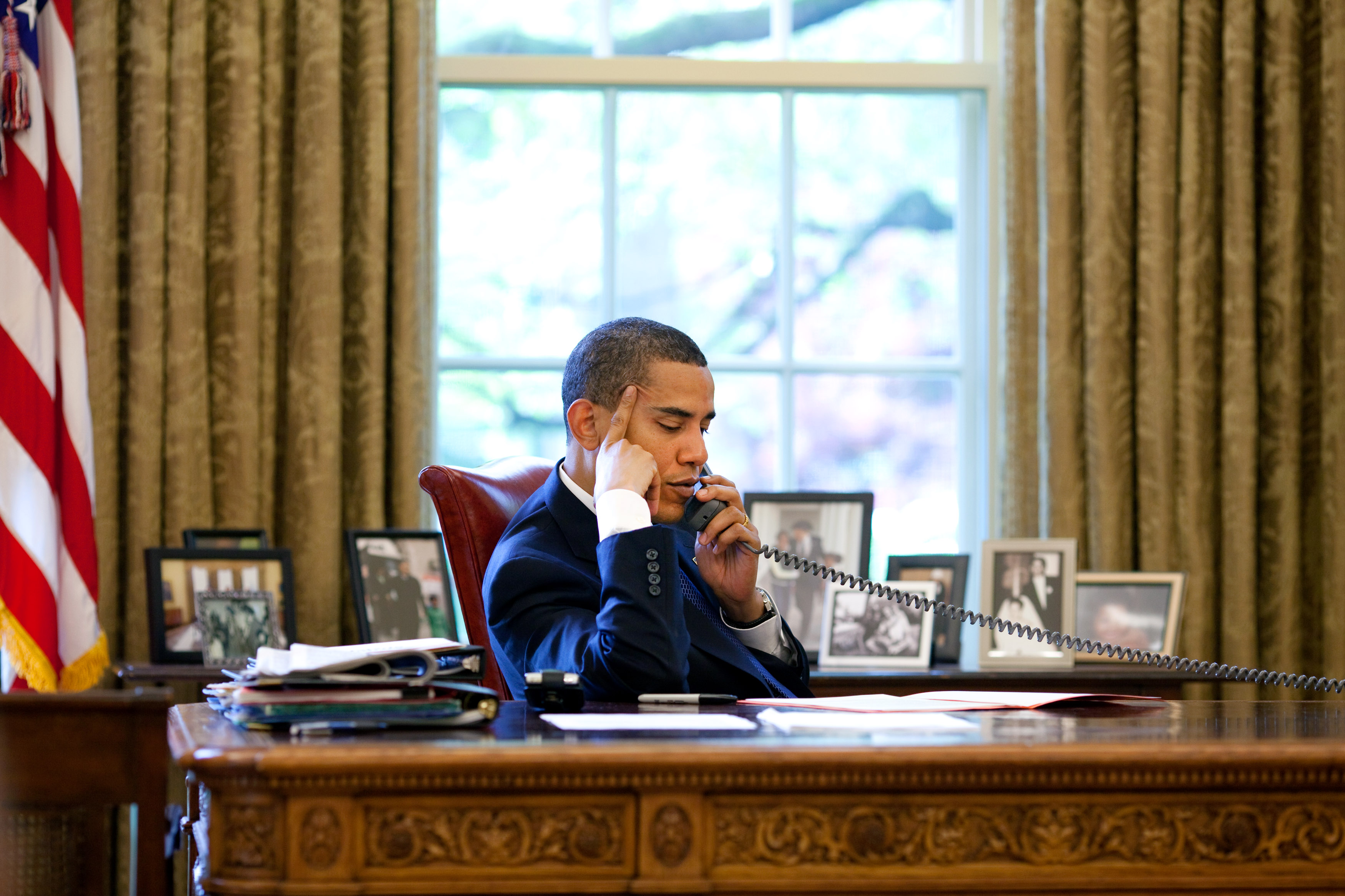 President Barack Obama sits at his desk in the  Oval Office during a phone call with Chinese President Hu Jintao May 6, 2009. Official White House Photo by Pete Souza.  This official White House photograph is being made available for publication by news organizations and/or for personal use printing by the subject(s) of the photograph. The photograph may not be manipulated in any way or used in materials, advertisements, products, or promotions that in any way suggest approval or endorsement of the President, the First Family, or the White House.