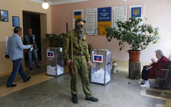 epa04201089 An armed pro-Russian activists stands guard near a ballot box during a referendum organized by the so-called Donetsk People's Republic members, at a polling station in Donetsk, Ukraine, 11 May 2014. Residents of eastern Ukraine began voting on an independence referendum that was organized by pro-Russian separatists and rejected by the government in Kiev. Russian-speakers and supporters of Moscow have been rallying in the region since March, when a referendum on independence led to Russia's annexation of Crimea. EPA/MAXIM SHIPENKOV